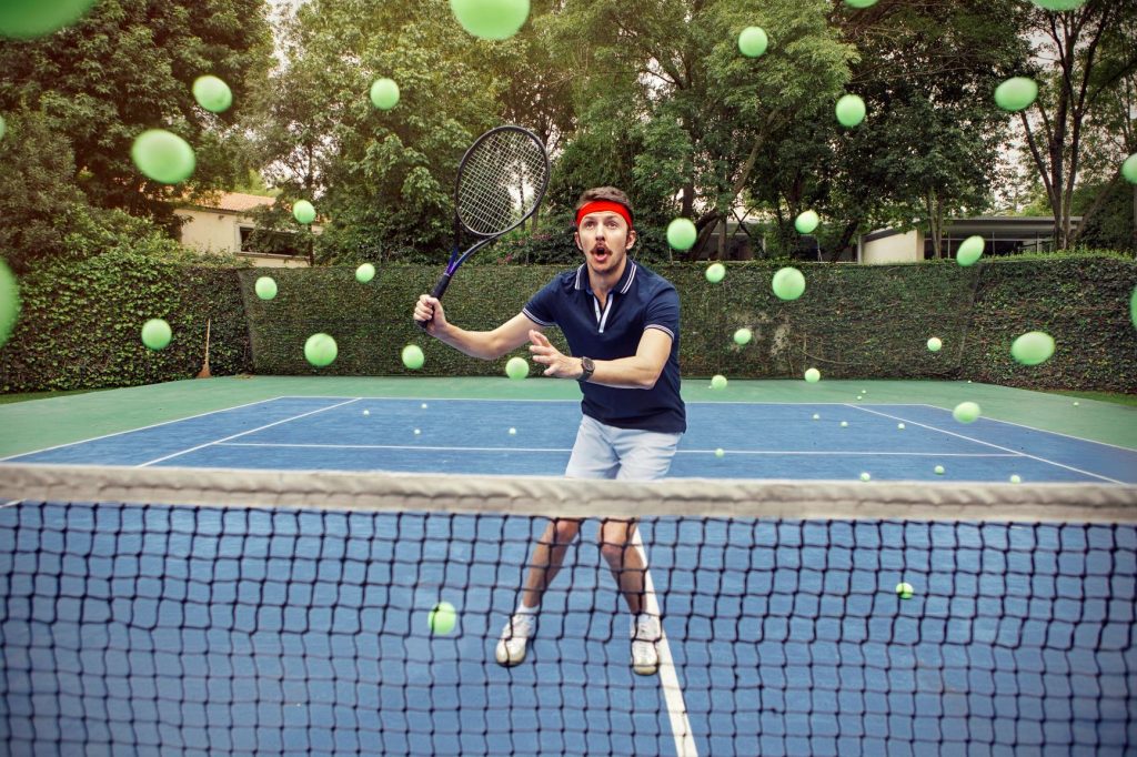 Tennis player struggling to hit lots of tennis balls